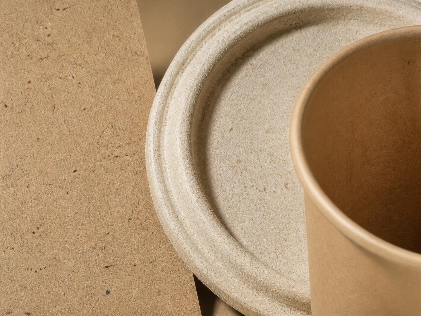 Close-up of recycled kraft board, a moulded sugarcane fibre lid and an uncoated paper cup rim